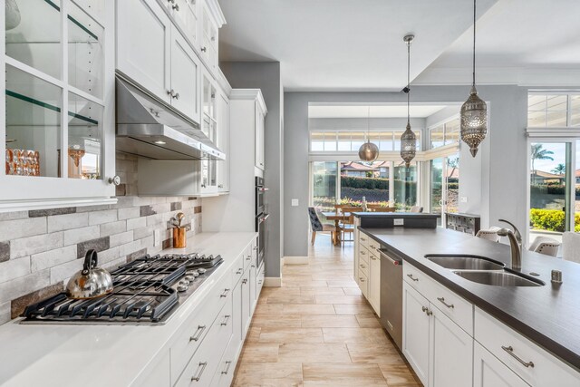 kitchen with white cabinetry, light wood-type flooring, appliances with stainless steel finishes, decorative backsplash, and sink