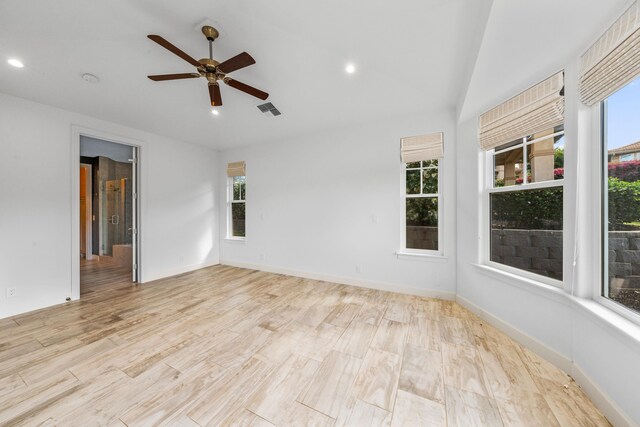 spare room featuring vaulted ceiling, ceiling fan, and light wood-type flooring