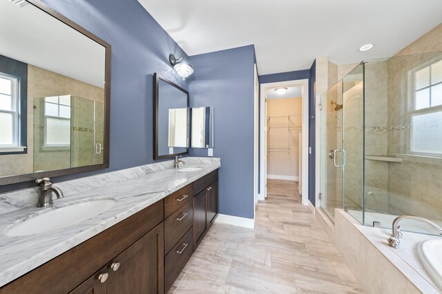 bathroom featuring plus walk in shower, tile patterned floors, a healthy amount of sunlight, and dual bowl vanity