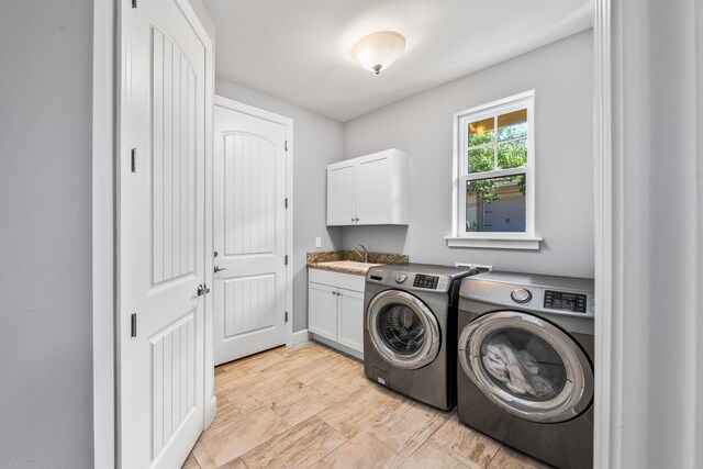 washroom featuring sink, cabinets, and washer and clothes dryer