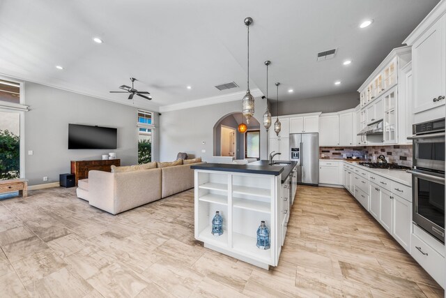 kitchen with white cabinets, backsplash, appliances with stainless steel finishes, and ceiling fan