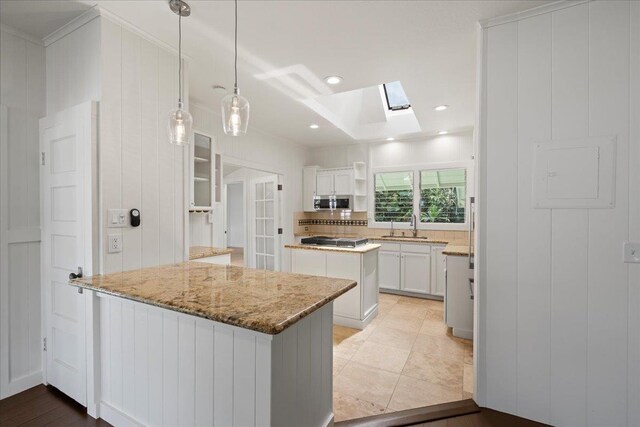 3217 Luahine Pl, Haiku, HI 96708 - kitchen with a skylight, stainless steel appliances, open shelves, a peninsula, and white cabinets