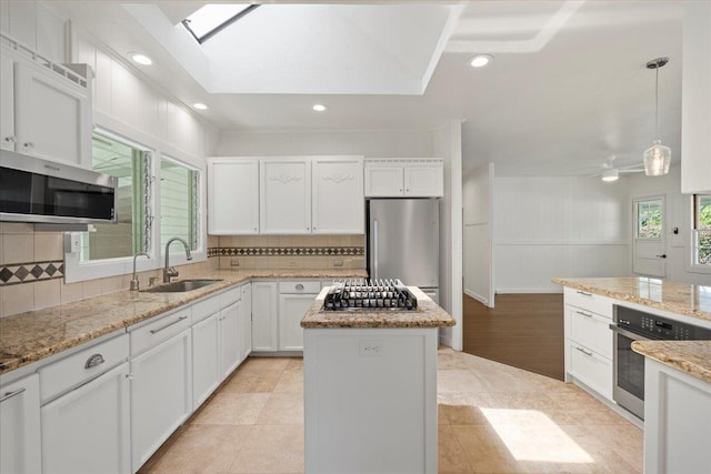 3217 Luahine Pl, Haiku, HI 96708 - kitchen featuring a sink, appliances with stainless steel finishes, a kitchen island, tasteful backsplash, and white cabinetry