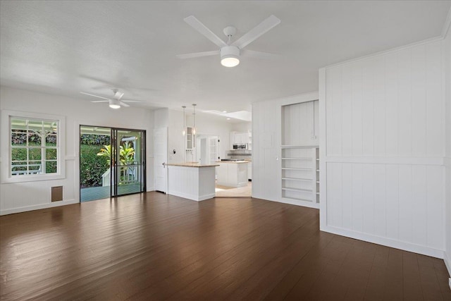 3217 Luahine Pl, Haiku, HI 96708 - unfurnished living room featuring ceiling fan, dark wood-type flooring, baseboards, and a decorative wall