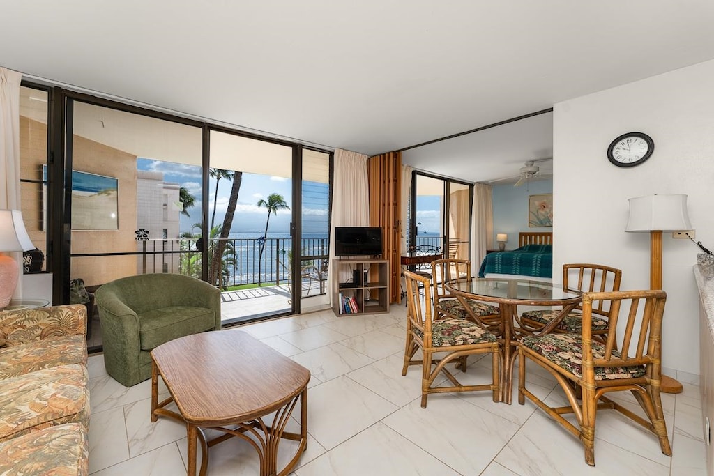 dining space featuring light tile floors, floor to ceiling windows, and ceiling fan