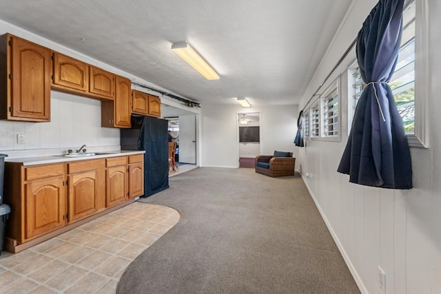 119 Kupalaiki Loop, Kihei, HI 96753 - kitchen with light countertops, a sink, brown cabinetry, light colored carpet, and baseboards