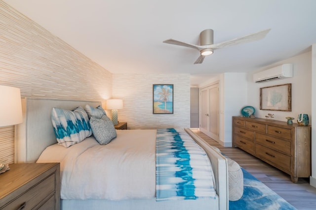 3200 Wailea Alanui Dr Unit 1606, Kihei, HI 96753 - bedroom featuring an AC wall unit, light wood-type flooring, and a ceiling fan