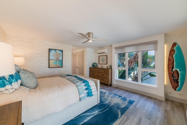 3200 Wailea Alanui Dr Unit 1606, Kihei, HI 96753 - bedroom featuring a wall mounted AC, wood finished floors, and a ceiling fan