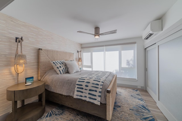 3200 Wailea Alanui Dr Unit 1606, Kihei, HI 96753 - bedroom with a wall mounted AC, ceiling fan, and light wood-style floors