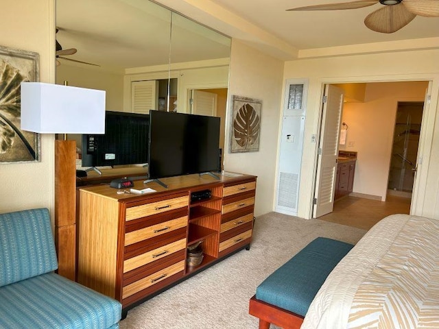 interior space featuring connected bathroom, ceiling fan, light colored carpet, and a closet