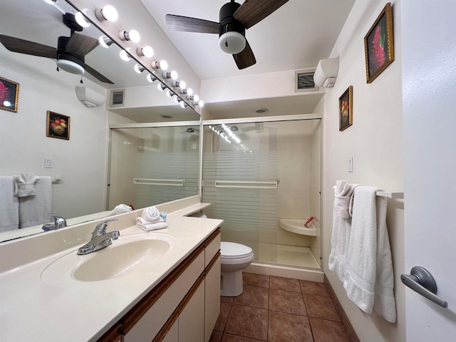 bathroom with ceiling fan, vanity with extensive cabinet space, an enclosed shower, toilet, and tile floors