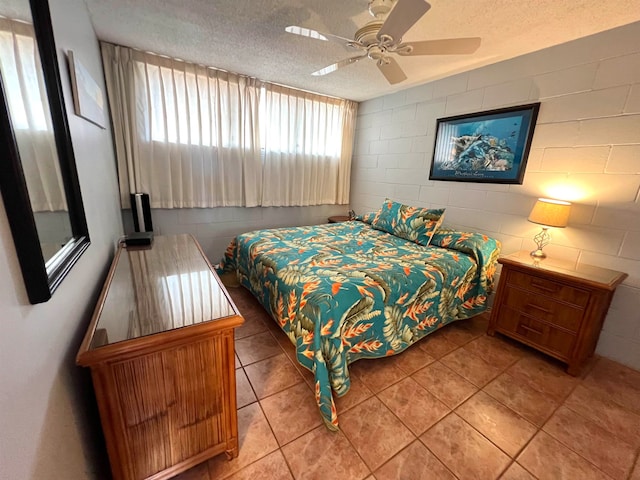 tiled bedroom with ceiling fan and a textured ceiling