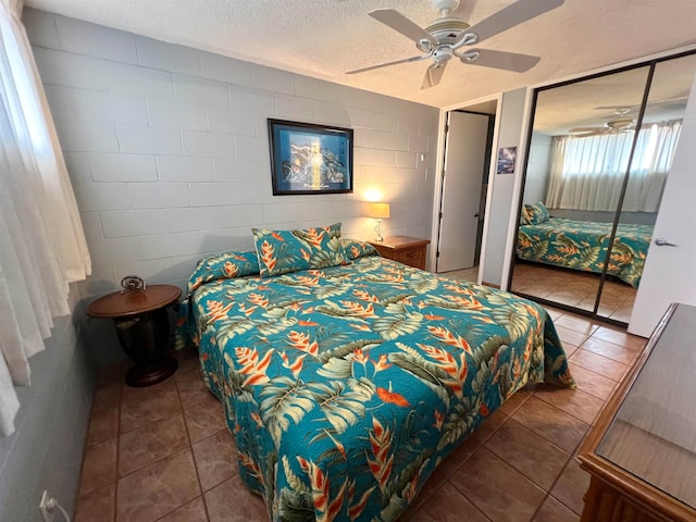 bedroom featuring tile floors, ceiling fan, and a textured ceiling