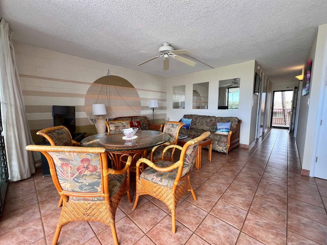 tiled dining room with ceiling fan and a textured ceiling