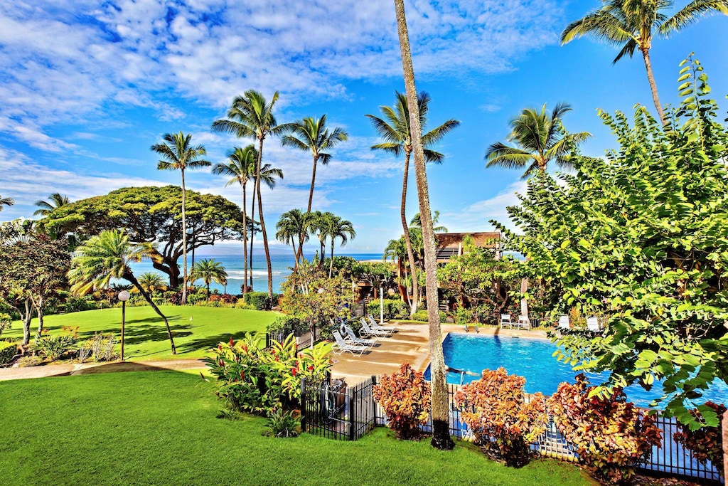 view of swimming pool featuring a water view and a lawn