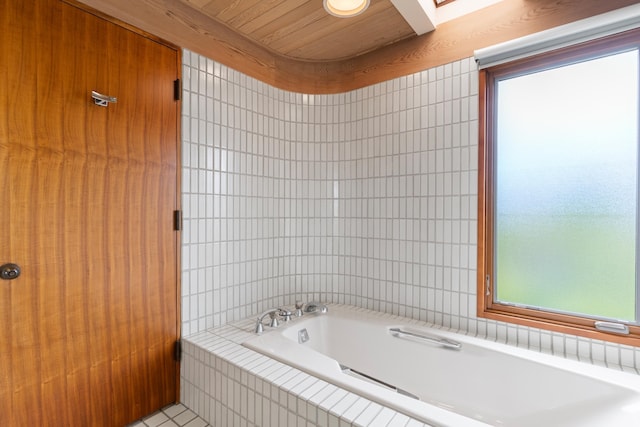 bathroom featuring a bath to relax in and tile floors