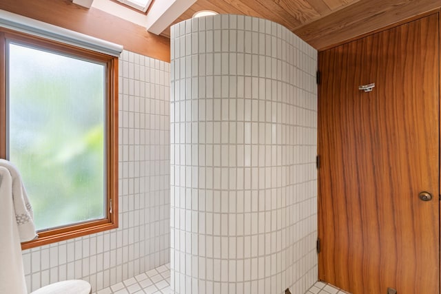 bathroom featuring tiled shower, tile walls, and wood ceiling