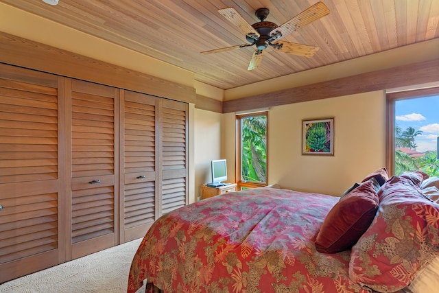 bedroom with wood ceiling, a closet, ceiling fan, and multiple windows