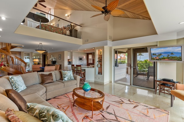 living room featuring wood ceiling, tile floors, ceiling fan, and a towering ceiling