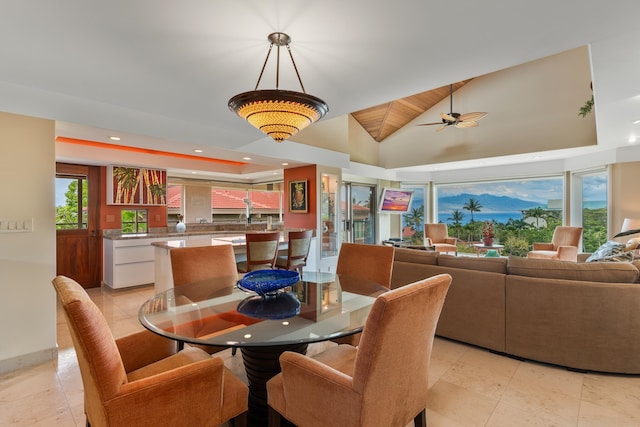 tiled dining area with lofted ceiling and ceiling fan