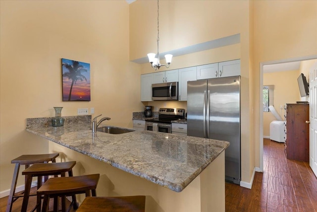 kitchen with stainless steel appliances, sink, kitchen peninsula, and a breakfast bar