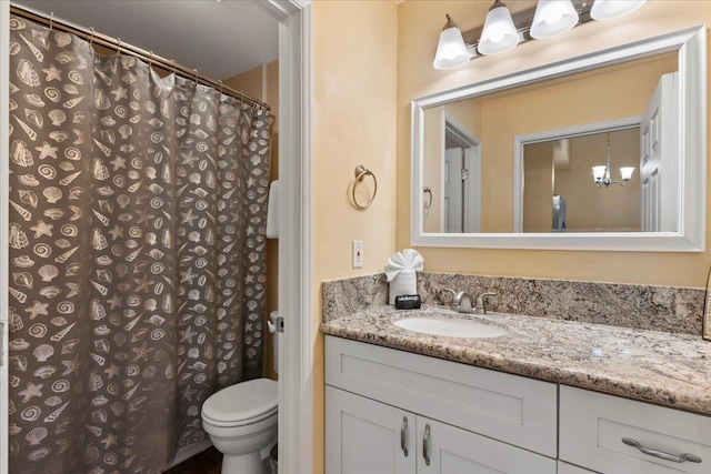 bathroom with a chandelier, walk in shower, vanity, and toilet