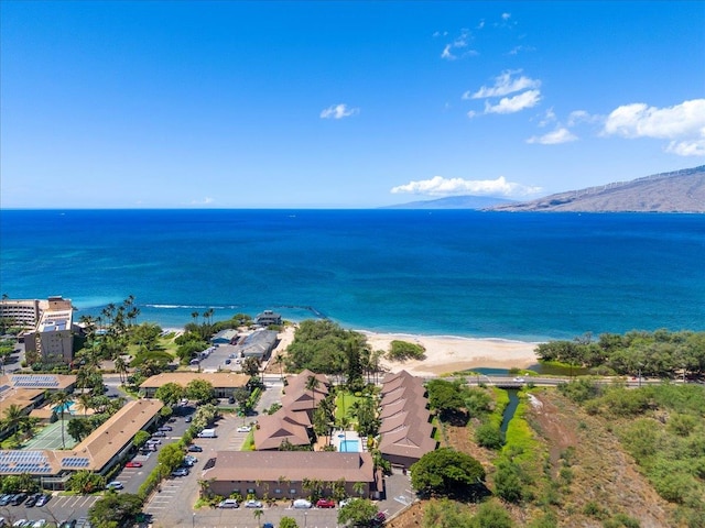 drone / aerial view featuring a view of the beach and a water and mountain view