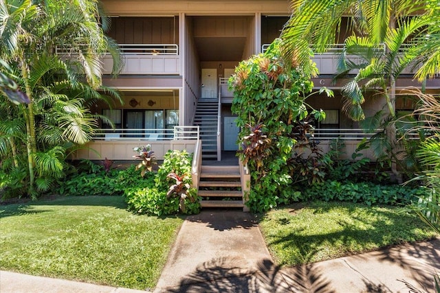 property entrance with a balcony and a yard