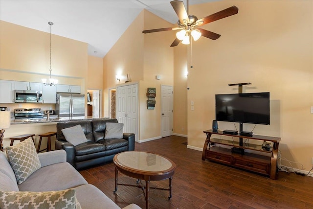 living room featuring ceiling fan with notable chandelier, high vaulted ceiling, and dark hardwood / wood-style floors