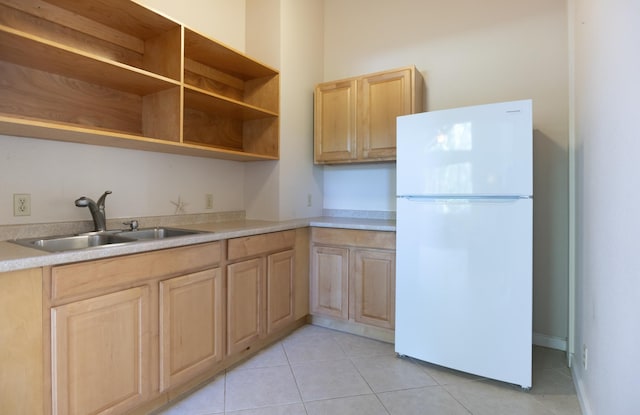 kitchen featuring white refrigerator, light tile patterned floors, sink, and light brown cabinets