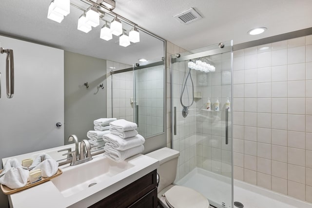 bathroom with toilet, a textured ceiling, walk in shower, and vanity