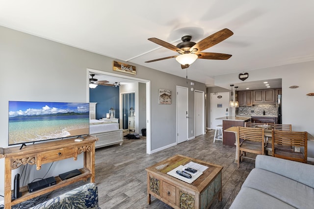 living room featuring ceiling fan and dark wood-type flooring