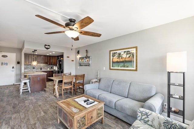 living room with dark hardwood / wood-style floors and ceiling fan