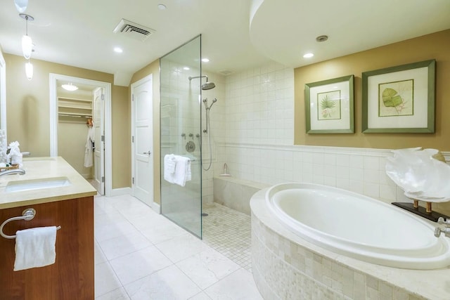 bathroom with tile patterned floors, vanity, and independent shower and bath