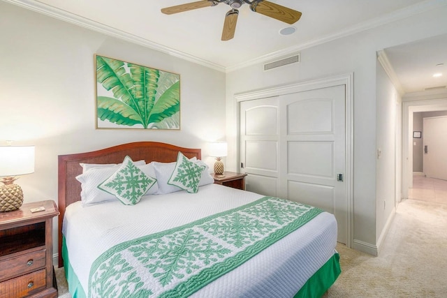 carpeted bedroom featuring crown molding, a closet, and ceiling fan