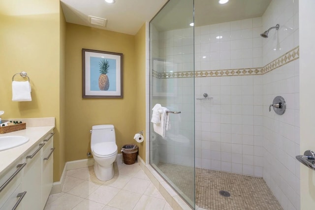 bathroom featuring vanity, toilet, tile patterned flooring, and a tile shower