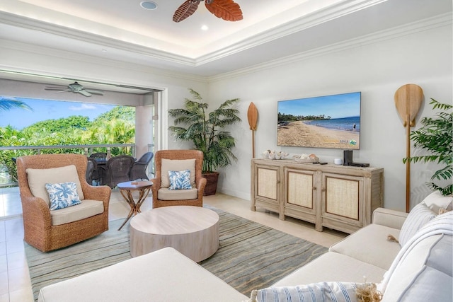 living room featuring ceiling fan, ornamental molding, a tray ceiling, and light tile patterned floors