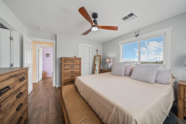 bedroom featuring dark wood-type flooring, baseboards, visible vents, and ceiling fan