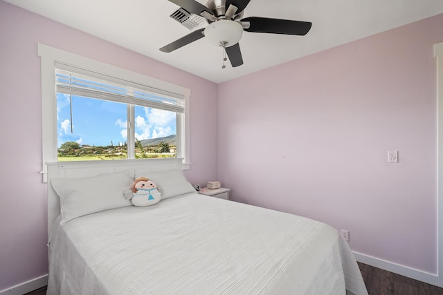 bedroom featuring dark wood finished floors, a ceiling fan, and baseboards