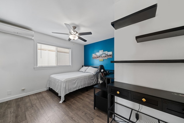 bedroom featuring ceiling fan, baseboards, an AC wall unit, and wood finished floors