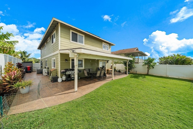 back of property with a patio area, a lawn, and a fenced backyard