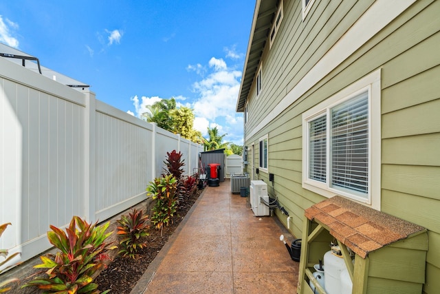 view of patio with central air condition unit, a fenced backyard, and ac unit