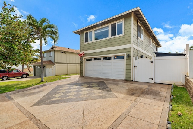 view of front facade with a garage, fence, driveway, and a gate