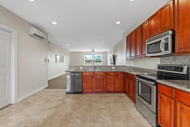 kitchen featuring appliances with stainless steel finishes, light carpet, sink, kitchen peninsula, and a wall unit AC