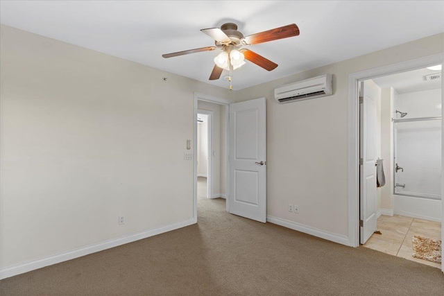 unfurnished bedroom with light colored carpet, a wall mounted air conditioner, connected bathroom, and ceiling fan