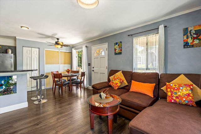 living room with ornamental molding, ceiling fan, and dark wood-type flooring