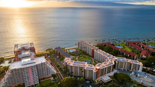 aerial view at dusk featuring a water view