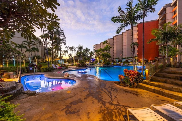 pool at dusk featuring a patio area