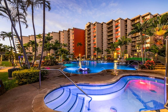 pool at dusk with a patio area