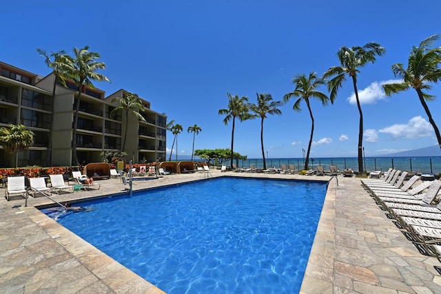 view of swimming pool featuring a patio area and a water view